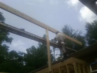 Carpenter setting a ridge beam over a new addition frame — Ice Dam Removal by Roofing Brothers in North Judson