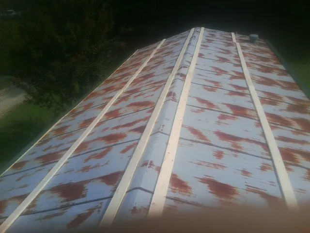 Rusted metal roof panels with new wood purlins before replacement — Storm Damage Roof Repair in North Judson by Roofing Brothers