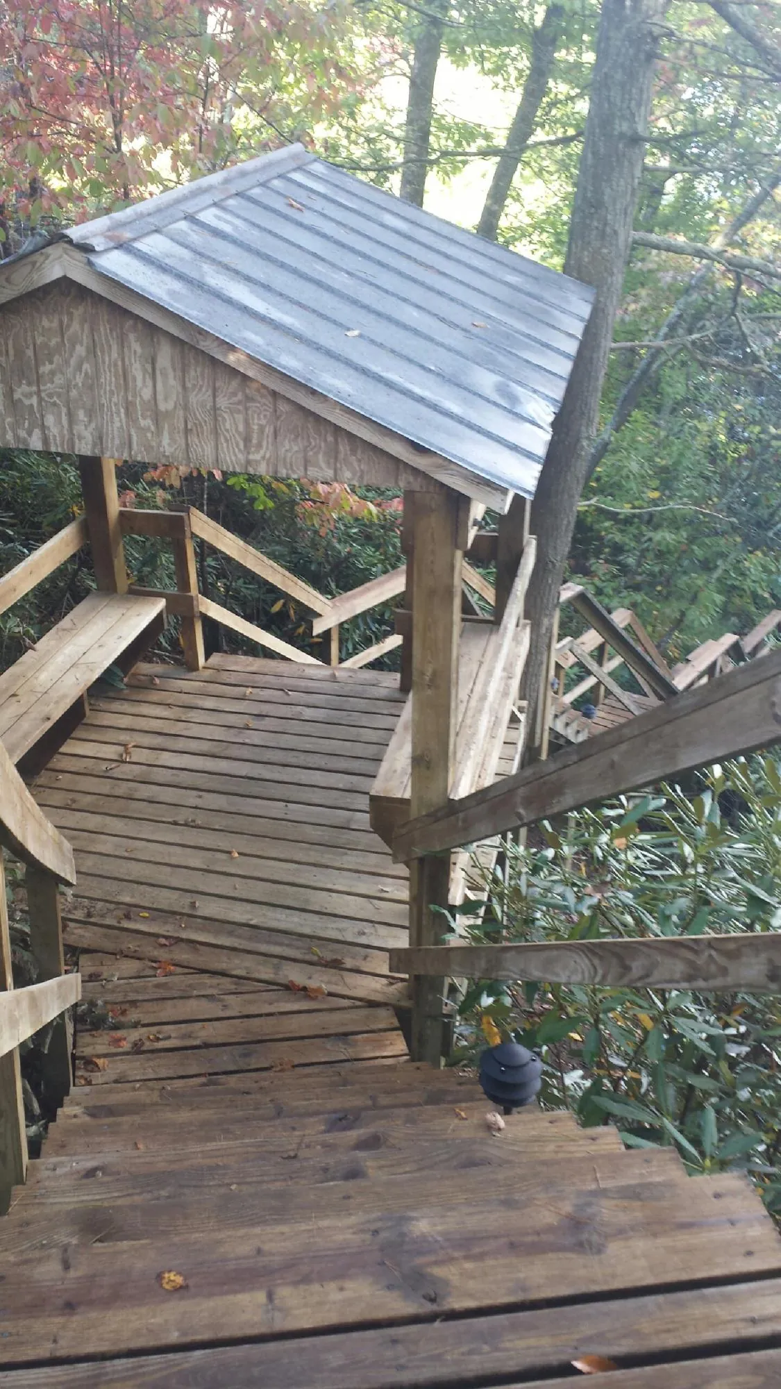 Metal roofed shelter over wooden steps on a wooded walkway — Skylight Repair & Installation work by our crew in North Judson