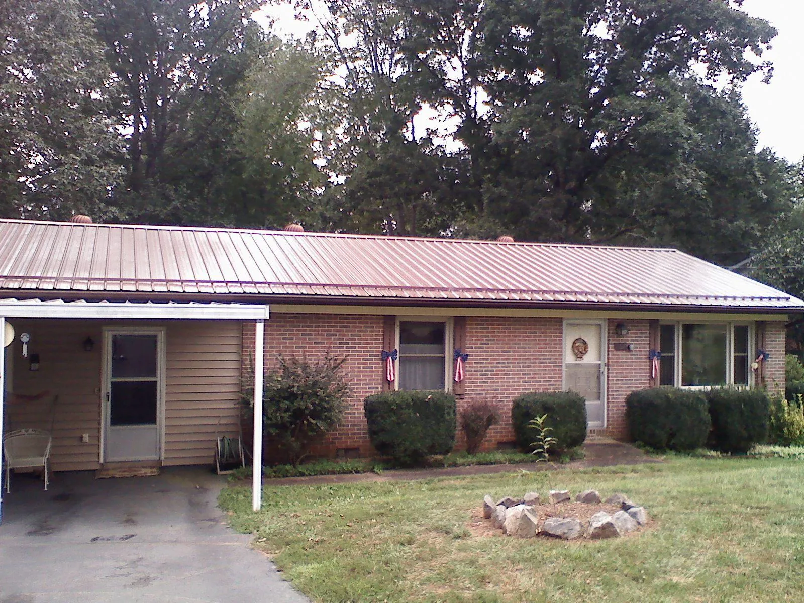 Bronze metal roof and carport on a brick ranch home — Roof Repair work by our crew in North Judson